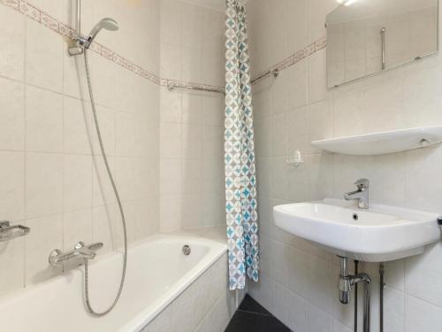 a bathroom with a shower and a sink and a bath tub at Holiday Home by Grevelingenmeer & Brouwersdam in Brouwershaven