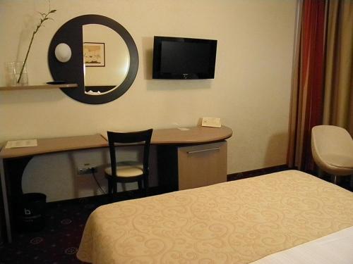 a hotel room with a desk and a bed at Hotel Berthelot in Bucharest