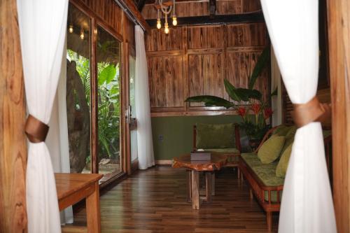 a person looking through a curtain into a living room at Asia Tropical Resort and Spa in Làng Coc