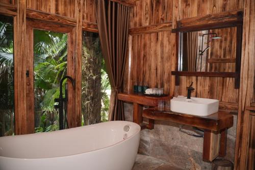 a bathroom with a bath tub and a sink at Asia Tropical Resort and Spa in Làng Coc