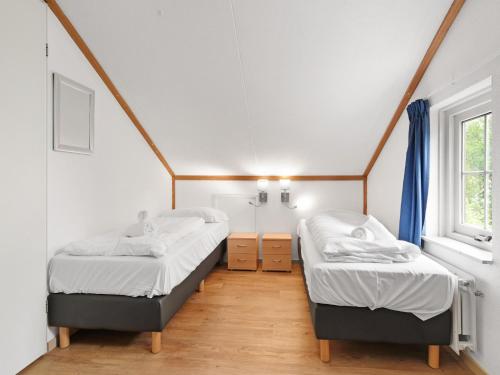 two twin beds in a room with a window at Holiday Home by the Sea in Brouwershaven