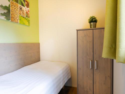 a small bedroom with a bed and a cabinet at Cozy Forest Retreat Near Putten in Putten