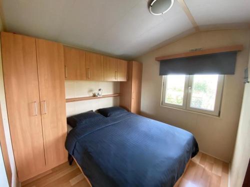 HippolytushoefにあるChalet in Wiringherlant with Garden Terraceの青いベッドと窓のある寝室