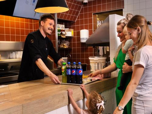 a group of people standing in a kitchen at Cozy Forest Retreat Near Putten in Putten