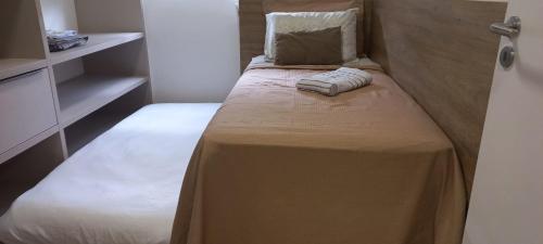 a small bedroom with a bed with a pillow at Apto Clássico - luxo perto da WEG in Jaraguá do Sul