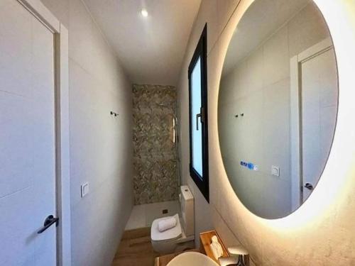 a bathroom with a large mirror and a toilet at Apartment in Puerto del Rosario near Playa Chica in Puerto del Rosario
