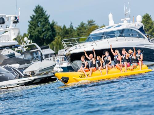 a group of girls are riding on a yellow raft in the water at Chalet by the Water in Leukermeer in Well