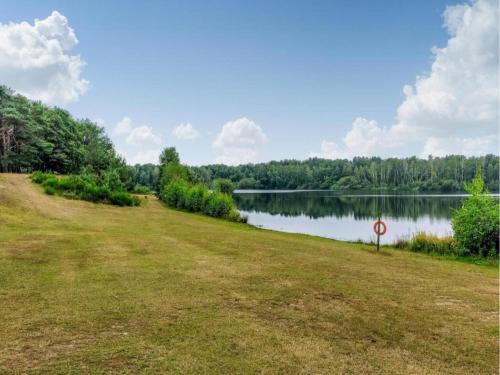 a large grassy field next to a lake at Chalet by the Water in Leukermeer in Well