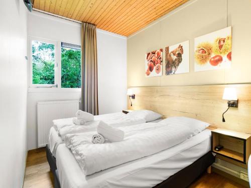 ein Schlafzimmer mit zwei Betten und einem Fenster in der Unterkunft Bungalow in Putten near Veluwe Nature Park in Putten