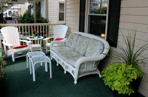 a couch sitting on a porch with two chairs and a table at King Charles Hotel in Ocean City