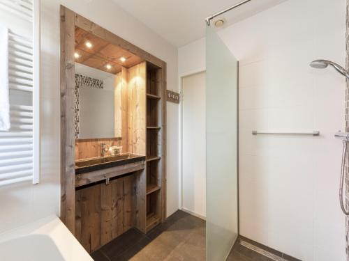 にあるHoliday Home in Diessen near Green Parkのガラスのシャワーと洗面台を備えたバスルーム