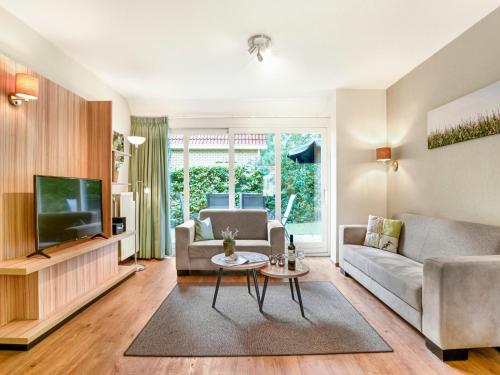 a living room with a couch and a tv at Holiday Home in Diessen near Tilburg 