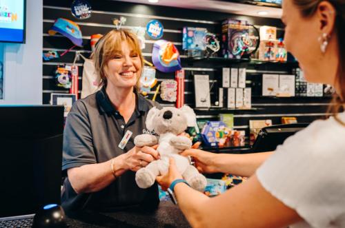 a woman sitting at a counter holding a teddy bear at Phillip Island Park Lane Holiday Park in Cowes