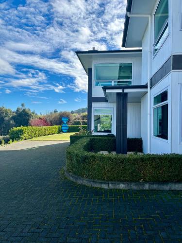a white house with a driveway at Punawai Homestay in Taupo