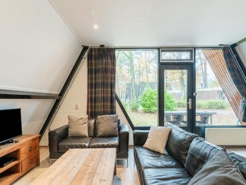 a living room with a couch and a tv at Holiday Home in North Limburg in Stramproy