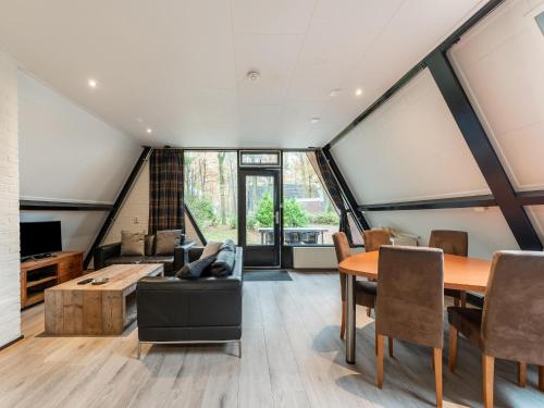 a room with a table and chairs and a couch at Holiday Home in North Limburg in Stramproy