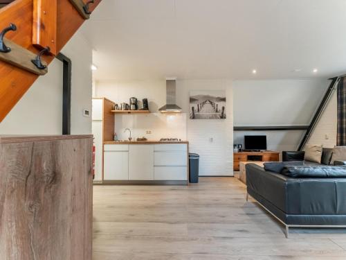 a living room with a couch and a kitchen at Holiday Home in North Limburg in Stramproy