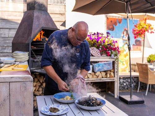 a man preparing food in front of an oven at Holiday Home near Grevelingenmeer Lake in Brouwershaven