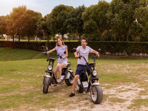 a man and woman riding on scooters in a park at Holiday Home near Grevelingenmeer Lake in Brouwershaven