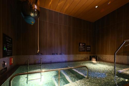 a large swimming pool in a room with at Dormy Inn Express Unnan Natural Hot Spring in Satogata