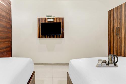 インドールにあるTownhouse Veena Nagar Bus Terminal Formerly Hotel Chandraguptaのリビングルーム(テレビ、白いテーブル付)