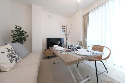 a dining room with a table and a couch at Cozy Nest Nakano 2 stops 5 min to Ikebukuro 7 stops to Shinjuku 15 min new 1LDK in Tokyo