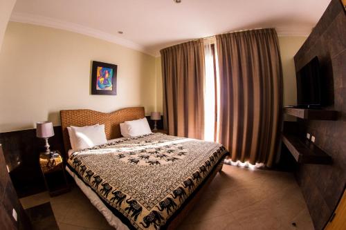 a bedroom with a bed and a window with curtains at Dharma Beach in Montañita