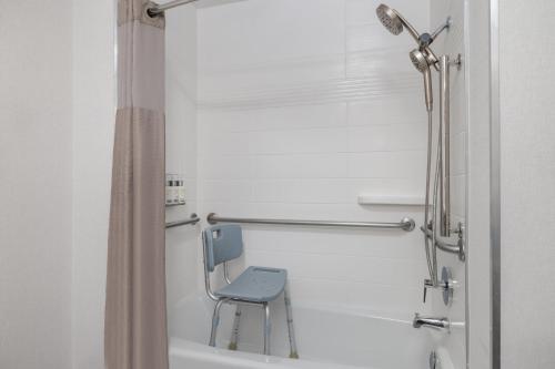a shower with a blue chair in a bathroom at Garner Hotel Boise Airport by IHG in Boise