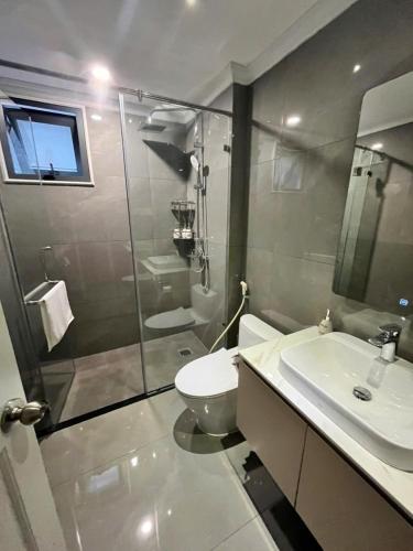 a bathroom with a shower and a toilet and a sink at Hoang Dung Hotel and Apartment by THC Group in Thuan An