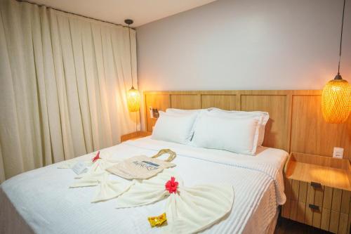 a hotel room with a bed with flowers on it at Pousada Aconchego Noronha in Fernando de Noronha
