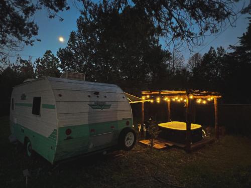 an rv with a tent and a tub at night at Dreamy Retro RV with Jacuzzi in Velasco