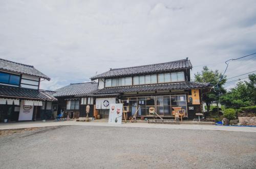 a building with a store on the side of a street at 佐渡古民家一棟貸切 Active Art Hotel 日本庭園 佐渡アート in Sado