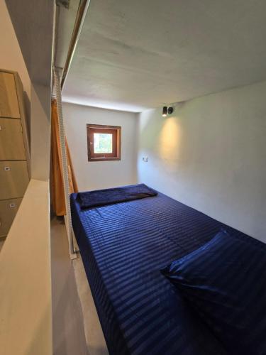 a bedroom with a blue bed in a room at Snuggy Hostel Kuta in Kuta Lombok
