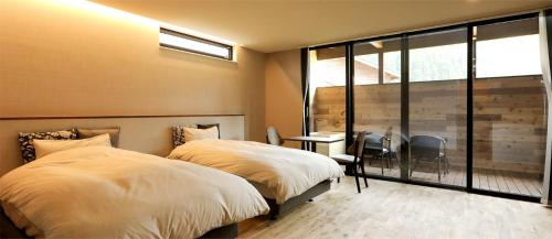 a bedroom with two twin beds and a window at Hotel 4CROWNS-PREMIERE シルバープラン in Katsuyama