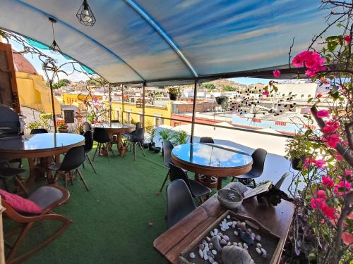 a patio with tables and chairs and a view of a boat at Boutique Hotel Casa Cid de León in Oaxaca City
