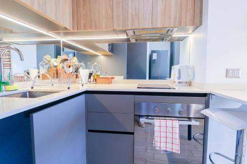 a kitchen with a sink and a stove at HOM I Depto con parking incluido 1D1B in Puerto Varas