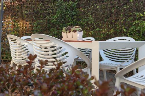 a white table and chairs with a potted plant on it at Beach Cottage in Mount Maunganui