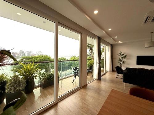 a living room with large windows and a view of the city at Aqua Apartments West Lake by XÔI Residences in Hanoi