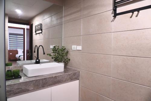 a bathroom with a sink and a mirror at Aqua Apartments West Lake by XÔI Residences in Hanoi