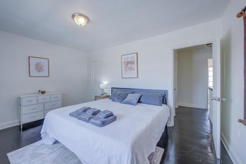 ein weißes Schlafzimmer mit einem Bett mit blauen Kissen darauf in der Unterkunft 20 Minute Walk to Tiger Stadium - Near Downtown in Baton Rouge