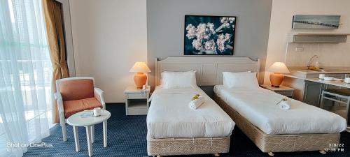 a hotel room with two beds and a kitchen at Rainbow paradise at Tanjung Bungah in Tanjung Bungah