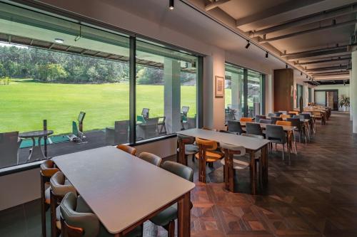 a restaurant with tables and chairs and a large window at Haeundae Beach Restfield in Busan