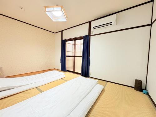 a room with three beds and a window at 夏様四条大宮 四条大宮駅5分 京都市中心部 一棟一組貸切 広い庭付き一戸建て in Kyoto