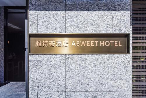 a sign on the side of a building at Yashihui Hotel in Qumul