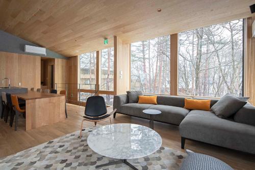 a living room with a couch and a table at Kairos by the Mountain by The Hakuba Collection in Hakuba