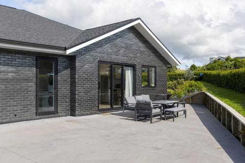 a patio with chairs and a table in front of a house at Brand New Unit only 4 km to Gisborne CBD in Gisborne