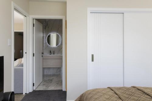 a bedroom with a mirror and a bed at Brand New Unit only 4 km to Gisborne CBD in Gisborne