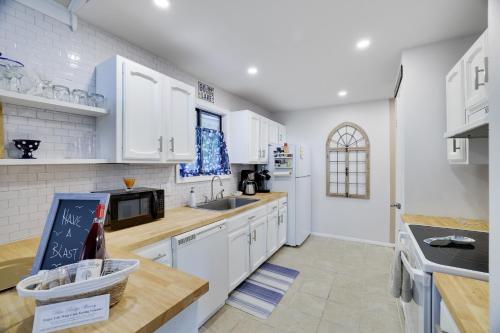 a kitchen with white cabinets and a counter top at Emerald Escape Lake, Theater, Game Room & More! in Long Pond