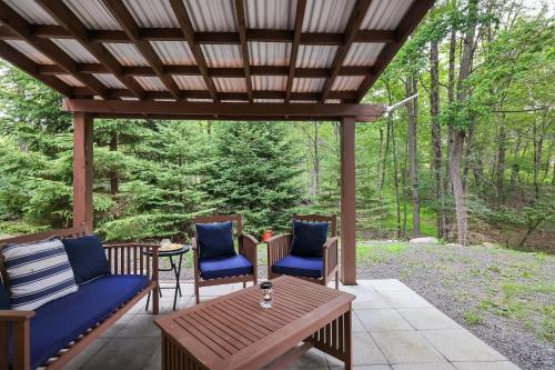 a patio with chairs and a table and a wooden pergola at Emerald Escape Lake, Theater, Game Room & More! in Long Pond