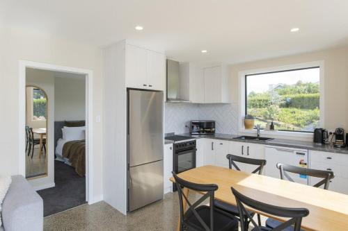 a kitchen with a table and a kitchen with a bed at Brand New Unit only 4 km to Gisborne CBD in Gisborne